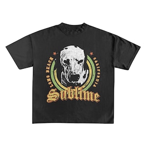 May include: Black t-shirt featuring a distressed graphic of a Dalmatian dog's face within a circular design. The design includes the text "Long Beach California" and "Sublime" in a vintage font. The shirt has short sleeves.