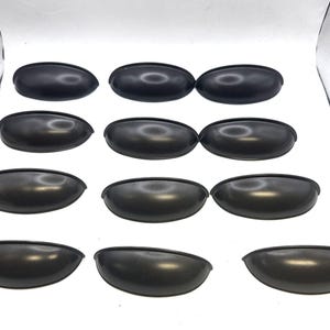 Op de afbeelding: Een verzameling van twaalf matzwarte metalen komgrepen, gerangschikt in vier rijen van drie. Elke greep heeft een glad, halfrond, komvormig ontwerp met een gebogen bovenrand en een platte montagebasis voor een consistente uitstraling.