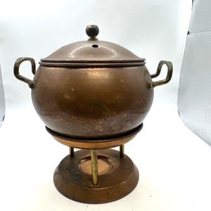 vintage copper potpourri or simmering pot with brass handles and a knob finial.