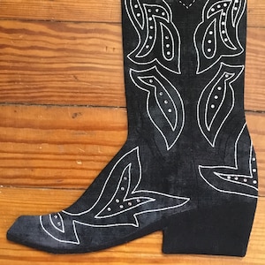 May include: Black cowboy boot with white stitching and rhinestones. The boot has a pointed toe and a high heel.