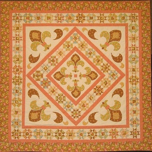 May include: A quilt with a central diamond shape surrounded by a border of smaller squares and a floral print. The diamond is filled with a repeating pattern of stylized fleur-de-lis in shades of brown, green, and cream. The border is in shades of peach, pink, and cream.