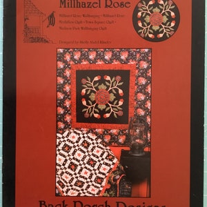 May include: A book cover with a red background and the title "Millhazel Rose" in black text. The cover features a quilt pattern with red and black flowers and leaves. The text "Back Porch Designs" is at the bottom of the cover.