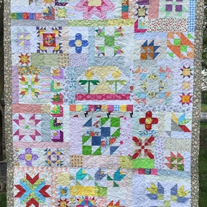 May include: A colorful patchwork quilt with a variety of geometric patterns and floral designs. The quilt is made up of many different fabrics in shades of pink, blue, green, yellow, and white.