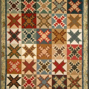 May include: A quilt with a patchwork design featuring a variety of colors and patterns, including red, blue, brown, and white. The quilt is made up of squares with different star patterns.