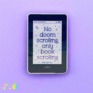 May include: A black Litbit e-reader with a white screen displaying the text "No doom scrolling, only book scrolling" in purple. The e-reader is on a light purple background. The words "DO NOT DISTURB MODE" are at the top.