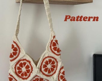 May include: A cream-colored crochet tote bag with orange citrus slice designs. The bag has a long strap and is hanging on a wall. The text "Citrus Breeze Tote" and "Pattern" are visible.