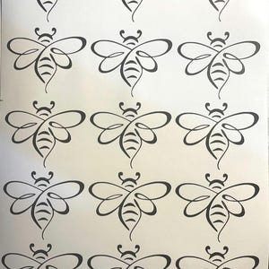 May include: A sheet of white paper with 15 black and white bee illustrations. Each bee is stylised with a curved body and wings.