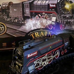 May include: A black toy train with red accents and the word "Railroad" printed on the side. The train has a working headlight and is on a track. The train is a toy model of a steam locomotive.