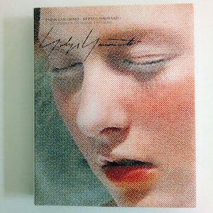 Könnte beinhalten: Ein Buchcover mit einer Nahaufnahme eines Gesichts mit geschlossenen Augen, das in einem Rasterpunktmuster dargestellt ist. Die Lippen sind rot, und es gibt eine schwarze Tintenunterschrift. Titel und Autorenname stehen oben.