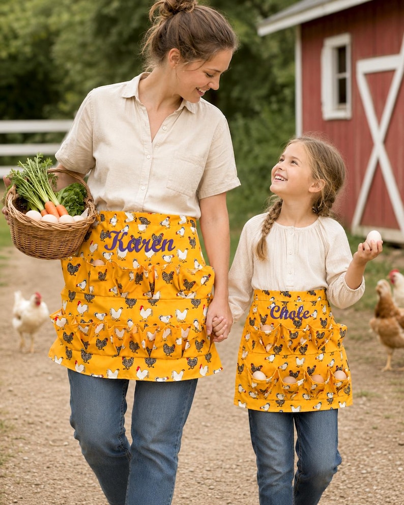 May include: Two mustard yellow aprons featuring a repeating chicken pattern and multiple pockets for egg collection. The larger apron is embroidered with the name Karen, and the smaller apron is embroidered with the name Chloe in purple script.