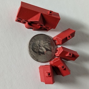 Puede incluir: Cinco casas rojas en miniatura sobre un fondo blanco. Las casas son aproximadamente del tama&ntilde;o de una moneda de 25 centavos de d&oacute;lar estadounidense.