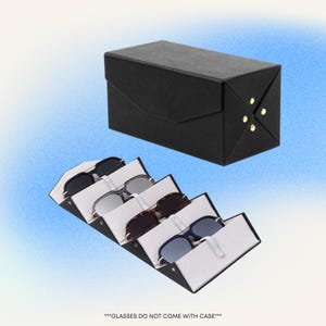 Pode incluir: Um estojo preto para óculos de sol com uma caixa de armazenamento preta a condizer. O estojo está aberto, revelando vários pares de óculos de sol. Os óculos de sol são de vários estilos e cores. O texto na parte inferior diz: "***OS ÓCULOS NÃO VÊM COM ESTOJO***".