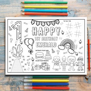 May include: A black and white printable colouring page for a 1st birthday party. The page features a large number "1", the words "Happy 1st Birthday Emerald", and various images including cakes, presents, balloons, a rainbow, and characters from the Wizard of Oz.