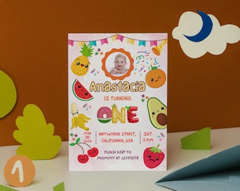 May include: A colorful birthday invitation featuring a photo of a baby, fruit illustrations, and the name "Anastacia." The invitation includes the text "IS TURNING ONE" and RSVP information. The design incorporates a cheerful, playful aesthetic.