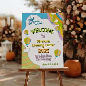 May include: A colorful welcome sign for a graduation ceremony at Pinetown Learning Center in 2025. The sign features a whimsical design with hot air balloons and the text "Oh! the Places You'll Go!"