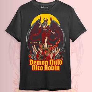 May include: Black t-shirt featuring a graphic of a female demon with wings, horns, and a red dress, standing in front of a yellow circle. The text "Demon Child Nico Robin" is displayed in yellow and red.