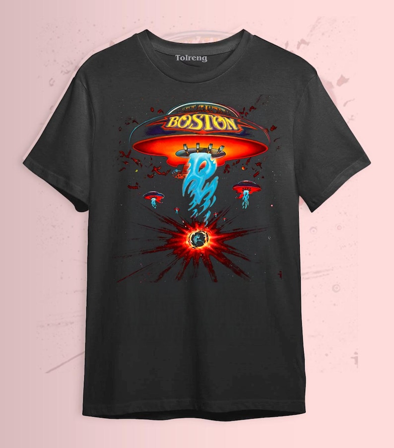 May include: Black t-shirt featuring a graphic design with the word "BOSTON" in gold lettering above a red and orange UFO. The design includes blue flames and smaller UFOs, with a burst of red and black radiating from a central point.