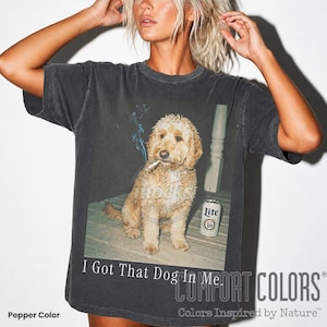 Op de afbeelding: Comfort Colors t-shirt in peperkleur met een afbeelding van een hond met een sigaret en een Lite bierblikje. De tekst "I Got That Dog In Me" staat onder de afbeelding.