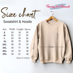 May include: A beige sweatshirt hangs on a wooden hanger, with a size chart displayed to the left. The chart lists sizes S to 5XL, with measurements in inches for width, length, and sleeve. The brand name "Truong Son Threads" is visible.