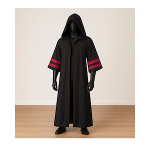 Puede incluir: Una larga túnica negra con capucha y rayas rojas en las mangas. La túnica se exhibe en un maniquí negro. La túnica tiene un diseño largo y fluido y está hecha de una tela oscura. Las mangas son anchas y terminan justo debajo del codo.