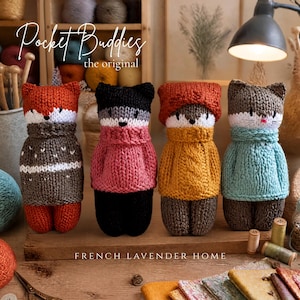 Puede incluir: Cuatro peluches de animales tejidos a mano con la etiqueta Pocket Buddies the original. De izquierda a derecha: un zorro con suéter gris, un animal negro con suéter rosa, un animal marrón con suéter y gorro amarillos, y un gato gris con suéter azul claro.