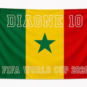 May include: A rectangular flag featuring the vertical tricolor of green, yellow, and red with a central green star. The text "DIAGNE 10" is printed in white at the top, and "FIFA WORLD CUP 2026" is printed in white at the bottom.
