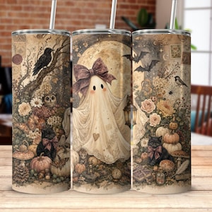 Può includere: Un bicchiere cilindrico con un'illustrazione in stile vintage di un fantasma con un grande fiocco, circondato da gatti neri, zucche, gufi, pipistrelli ed elementi floreali in tonalità seppia. Include una cannuccia e una grafica avvolgente.