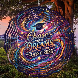 May include: A colorful graduation-themed wind spinner with the text "Chase Your Dreams Class of 2026". The design features a graduation cap, scroll, and a vibrant array of stars and swirling colors, perfect for outdoor decor.
