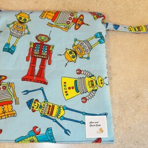 May include: A blue fabric zippered pouch with a yellow handle. The pouch is decorated with a repeating pattern of colorful robots. The pouch has a white label that reads "Mom and Child Cloth".