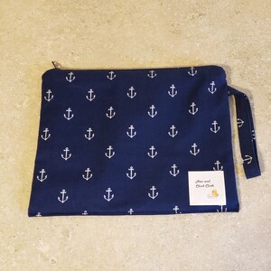 May include: A navy blue zippered pouch with a white anchor pattern and a white label that says "Hen and Chick Cloth".