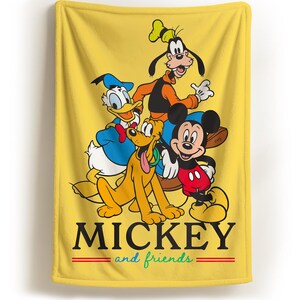 May include: Yellow blanket featuring Mickey Mouse, Donald Duck, Goofy, and Pluto. The blanket has the words "MICKEY" and "and friends" in black and green, with red stripes. The characters are in their classic cartoon styles.