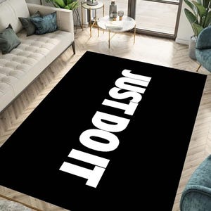May include: Black and white rug with the text "Just Do It" in white letters on a black background.