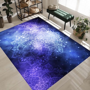 Puede incluir: Una alfombra azul y morada con un diseño de mandala blanco. La alfombra tiene un patrón de galaxia con estrellas y remolinos.