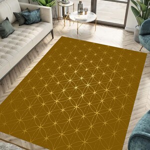 May include: A gold area rug with a geometric pattern of overlapping circles and stars. The rug has a brown background and gold accents.