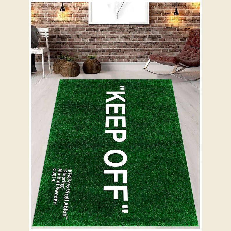 Puede incluir: Una alfombra verde con el texto "KEEP OFF" en letras blancas. El texto est&aacute; en negrita, sin serifas. La alfombra est&aacute; hecha de un material suave y mullido y tiene una textura realista similar a la hierba.