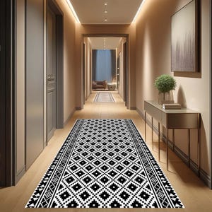 Op de afbeelding: Zwart-witte geometrische loper in een gang met beige muren en een houten vloer.