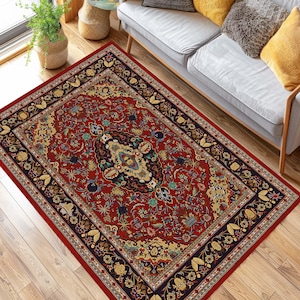 May include: A red, black, and gold patterned rug with a floral design. The rug has a central medallion with a geometric pattern.