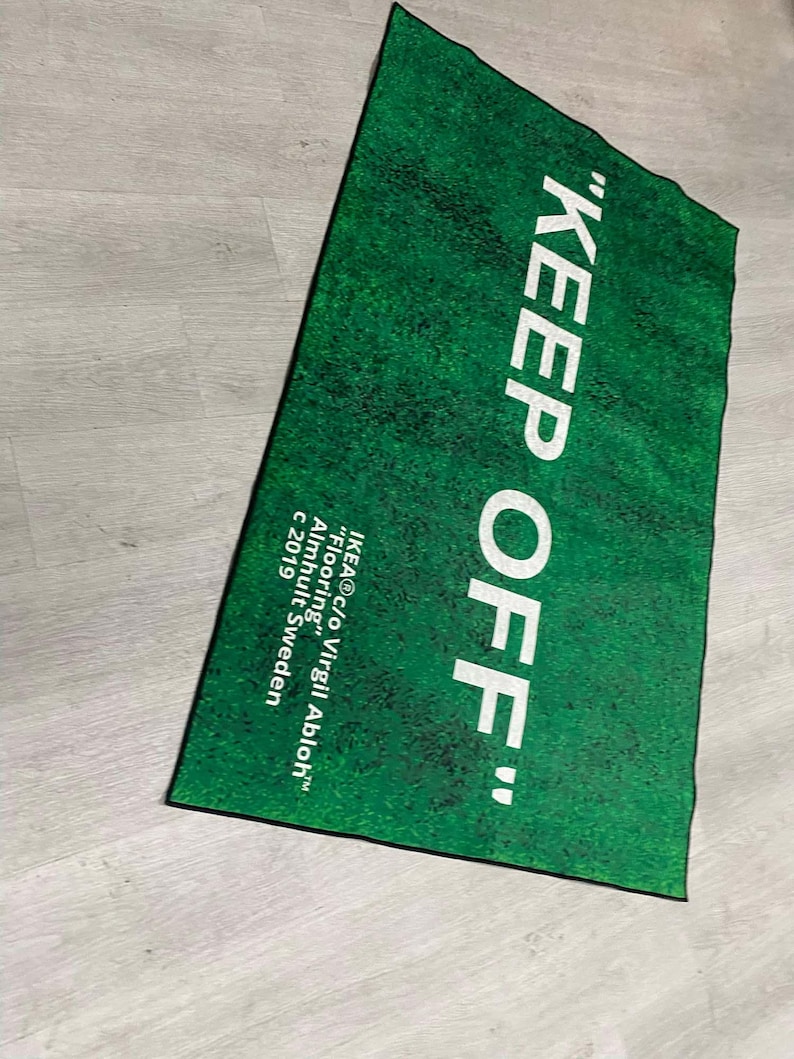Puede incluir: Una alfombra verde con el texto "KEEP OFF" en letras blancas. La alfombra tambi&eacute;n incluye el texto "IKEA c/o Virgil Abloh&trade;" "Flooring" "Almhult Sweden" "c 2019".
