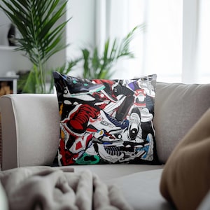 May include: A colorful throw pillow featuring a design of various sneakers in a pile. The sneakers are in a variety of colors, including red, blue, green, and black.