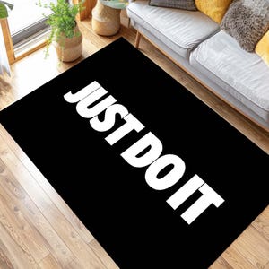 May include: Black and white rug with the text "JUST DO IT" in white letters.