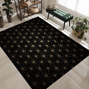 May include: Black and gold area rug with a geometric pattern of overlapping circles and lines.