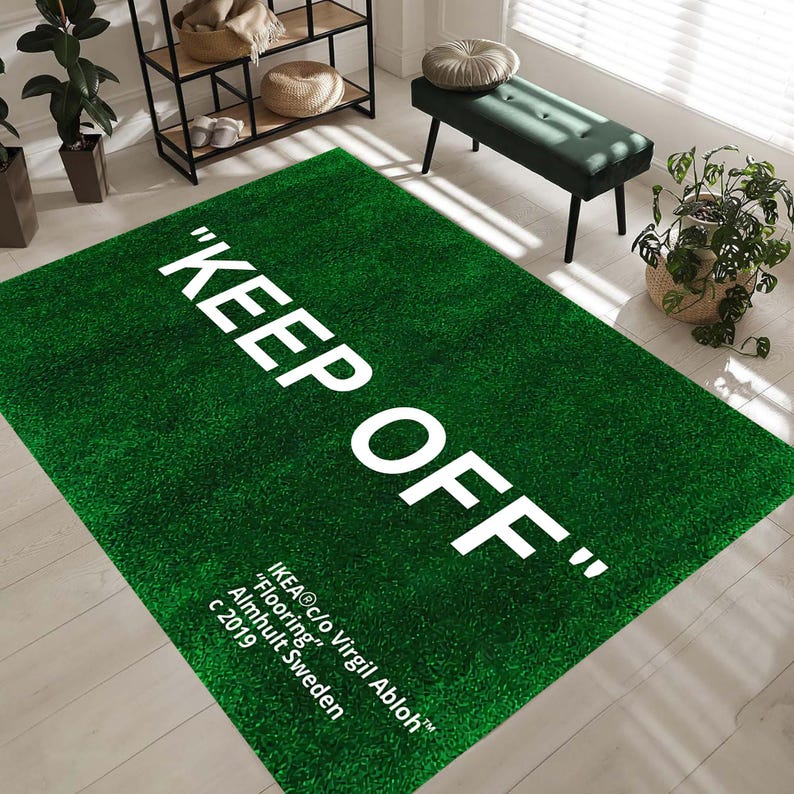 Puede incluir: Una alfombra de c&eacute;sped artificial verde con el texto "KEEP OFF" en letras blancas. La alfombra tiene el texto "IKEA&reg;c/o Virgil Abloh&trade;" "Flooring" Almhult Sweden c 2019 impreso en blanco.
