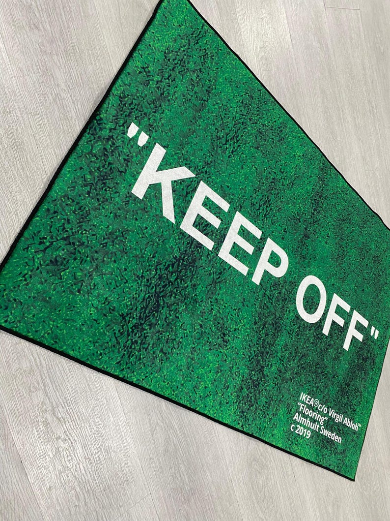 Puede incluir: Una alfombra verde con el texto "KEEP OFF" en letras blancas. La alfombra est&aacute; hecha por IKEA en colaboraci&oacute;n con Virgil Abloh.