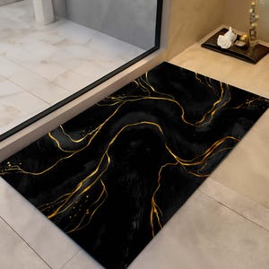 Pode incluir: Um tapete retangular preto com um design de mármore dourado. O tapete apresenta um fundo escuro com veios dourados fluidos, criando um visual luxuoso e elegante. O design lembra pedra natural.
