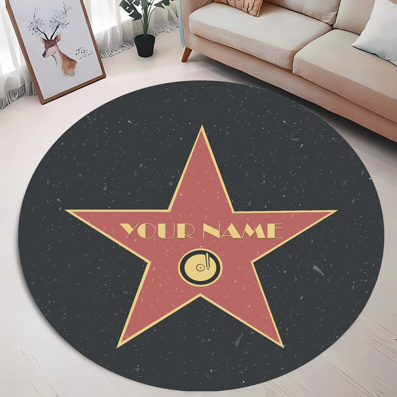 May include: A round black and red rug with a large red star in the center. The star has a yellow outline and the words "YOUR NAME" written in yellow letters. The rug has a speckled texture.