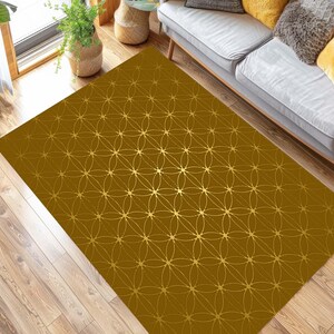 May include: A gold and brown patterned area rug with a geometric design. The rug has a subtle sheen and is perfect for adding a touch of elegance to any room.