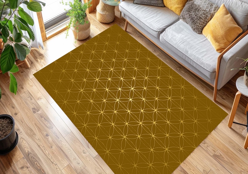 May include: A gold and brown patterned area rug with a geometric design. The rug has a subtle sheen and is perfect for adding a touch of elegance to any room.