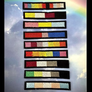 May include: Ten embroidered patches with different color combinations. Each patch has a black border and is rectangular. The patches are arranged vertically.