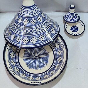 The distinctive domed lid and wide, shallow base adorned with a mosaic of geometric designs create a stunning piece of Moroccan cookware that serves as both a functional cooking vessel and a decorative centerpiece.