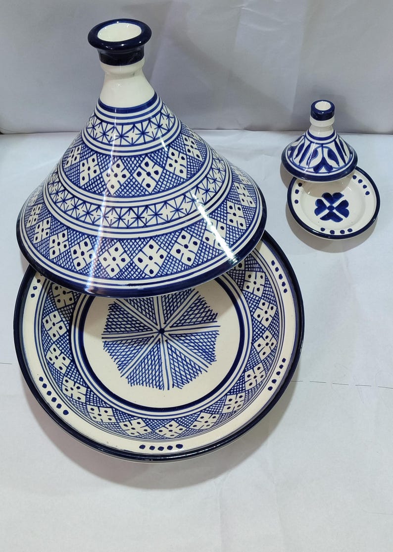 The distinctive domed lid and wide, shallow base adorned with a mosaic of geometric designs create a stunning piece of Moroccan cookware that serves as both a functional cooking vessel and a decorative centerpiece.